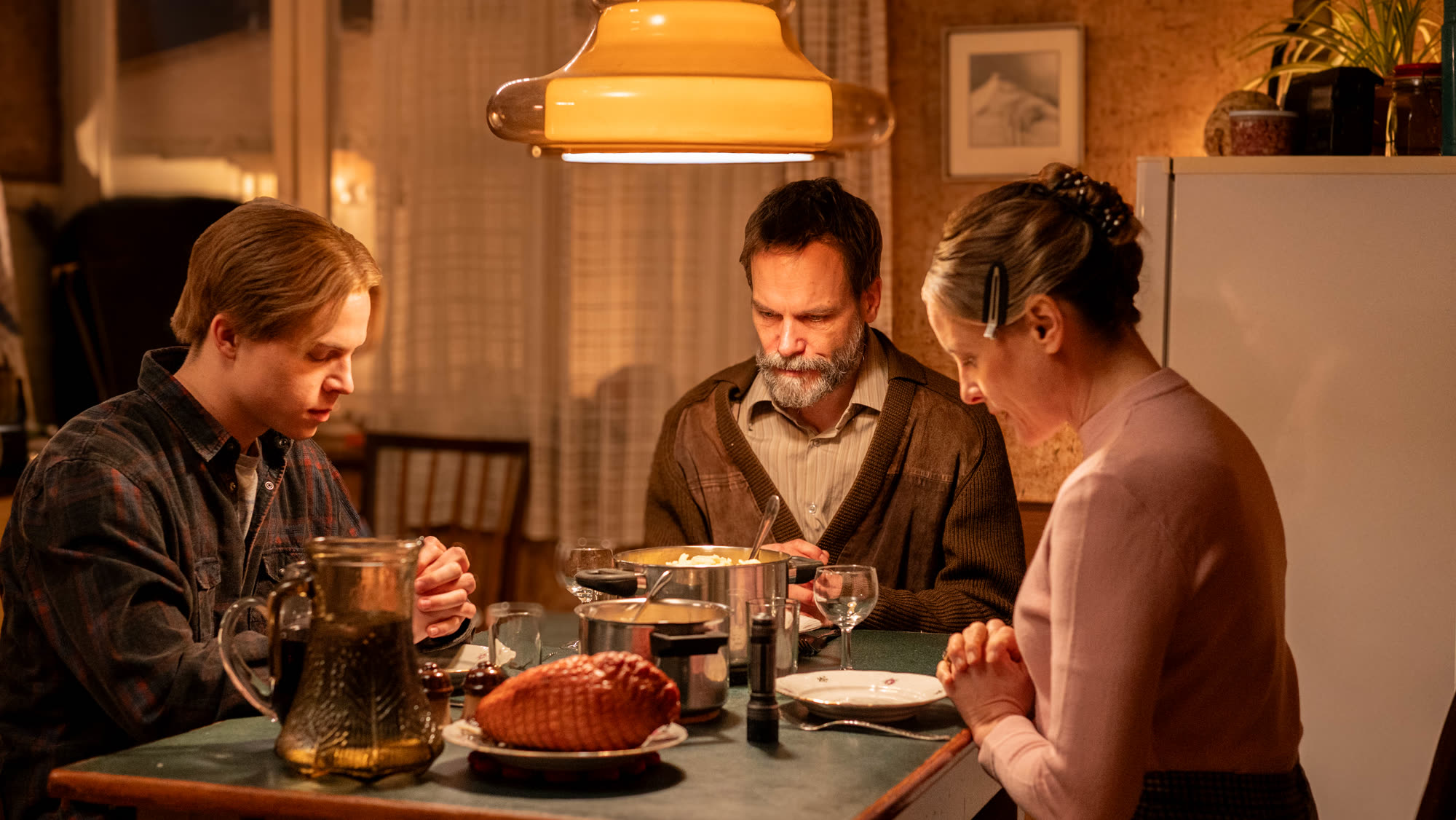 Szene aus Für Sibel: Eine Familie sitzt zum Essen am Tisch unter einer Hängelampe